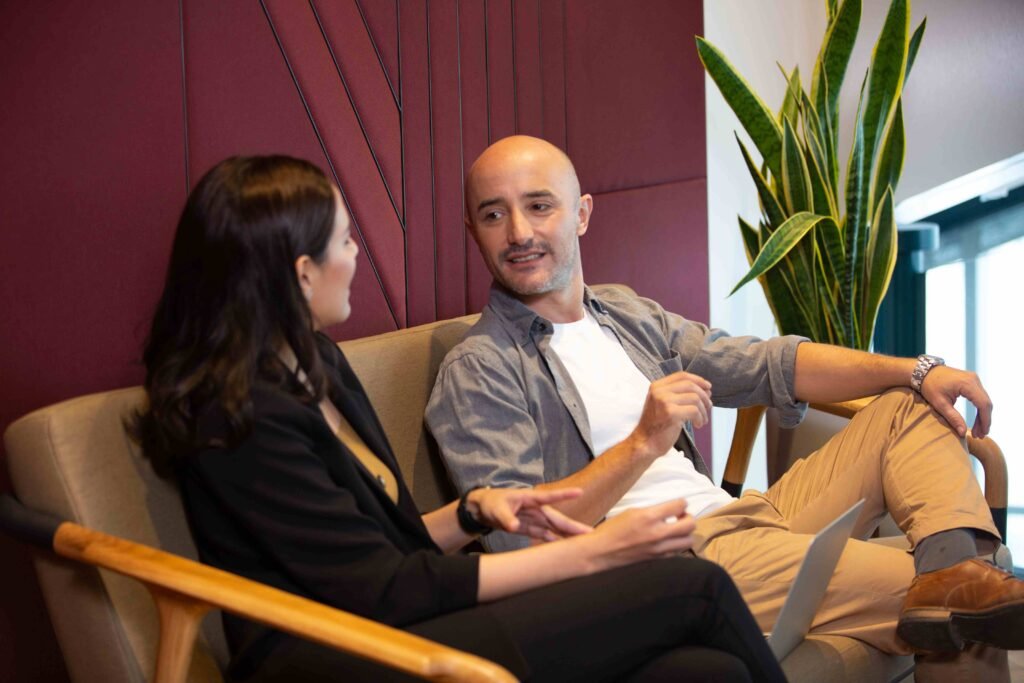 Two professionals sitting on a couch, engaged in a discussion. - best digital marketing company in Kochi