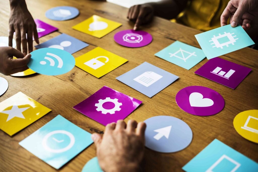 People arranging colorful cards with various technology icons. - Marketing and Digital Marketing Services
