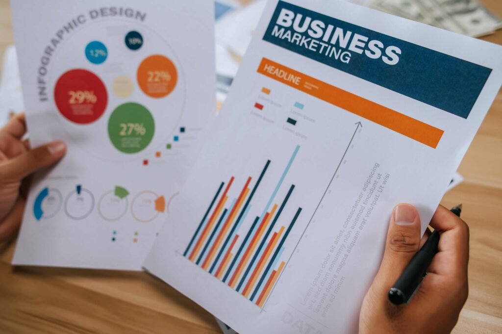 Hands holding business marketing documents with graphs and infographics