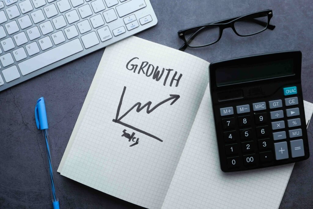 Notebook with "GROWTH" and a graph, beside a calculator. - best digital marketing company in Kochi